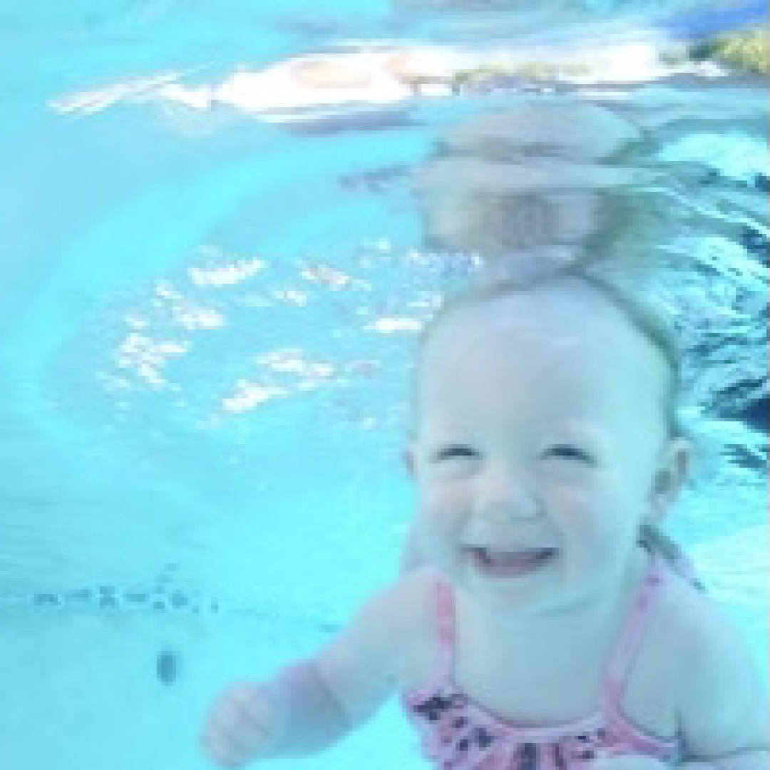 Baby wearing pink swimsuit underwater the swimming pool